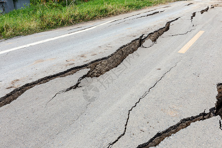 地震裂痕沥青路被破碎和损坏休息小伙子警告沥青水泥地面建造环境地震路面背景
