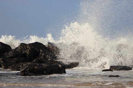 海岸对黑岩石的撞击波浪盐水水滴力量激流天气石头海浪风暴戏剧性支撑背景图片