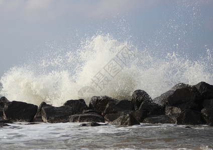 海岸对黑岩石的撞击波浪荒野石头风暴激流海洋水滴盐水蓝色支撑液体背景图片