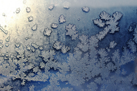 渐变图案冰雪花冰冻的窗户在冬天布满了霜霜器皿冷冻晴天季节雪花雾凇窗格学位寒冷太阳背景