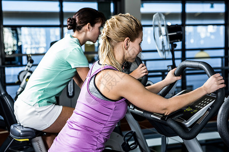 够强你就来参加运动车的妇女活动运动服健身室福祉女士自行车俱乐部运动员运动身体背景