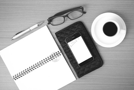 笔记本黑色咖啡 电话 眼镜 笔记和钱包细胞笔记本成功商业木头技术杯子桌子工作电脑背景