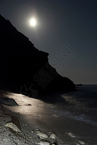 海滩在晚上月亮夜在海中黑暗海浪岩石石头孤独旅行天空场景海滩月光背景