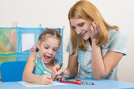 5岁女孩和年轻母亲在用蜡笔绘制快乐画画时玩得开心颜色高清图片素材
