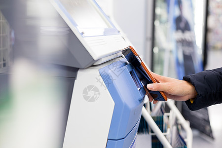 购物中心优惠券妇女通过移动电话和机器进行扫描;背景
