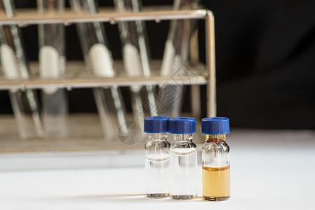 实验室玻璃器件前面的蓝盖小瓶化学技术学校生物液体化学家瓶子微生物学器皿实验背景图片