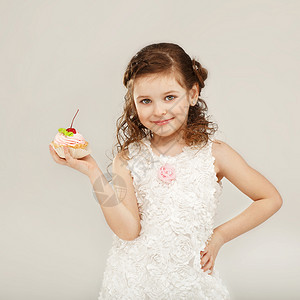 小女孩拿着一个美味的蛋糕和樱桃高清图片