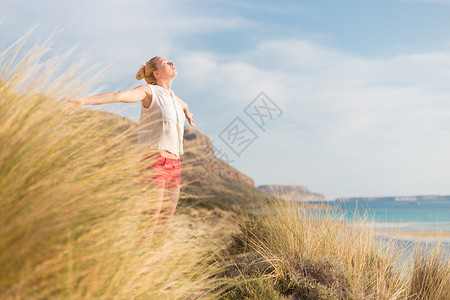 自由快乐的女子在节日中享受阳光幸福女孩衬衫喜悦太阳生活海滩头发女性沙丘浪漫的高清图片素材
