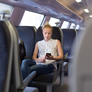 妇女在乘火车旅行时使用移动电话讲话手机技术互联网电话女士通勤者商业公共汽车乘客优雅的高清图片素材