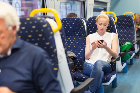 妇女在乘火车旅行时使用移动电话药片公共汽车商业女性技术运输互联网铁路乘客管理人员女士高清图片素材