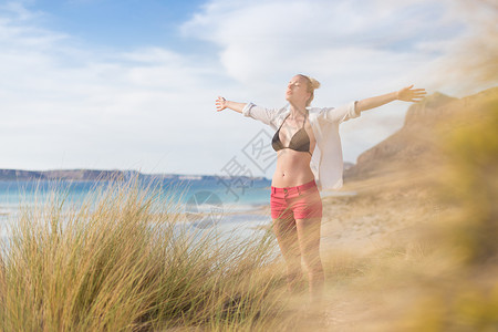 自由快乐的女子在节日中享受阳光女性女孩海滩生活喜悦沙丘太阳冥想幸福衬衫白色的高清图片素材