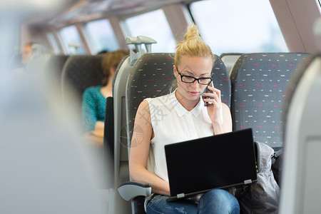 商业妇女乘火车旅行时从事工作通勤者乘客铁路药片公共汽车运输笔记本技术人士眼镜千禧一代高清图片素材