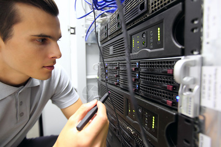 网络服务器机房中的男子房间服务硬件局域网技术工程师技术员数据中心电缆架子专业的高清图片素材