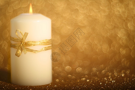 圣诞蜡烛在闪闪发光的背景上金子假期烧伤闪光辉光黄色卡片新年背景图片