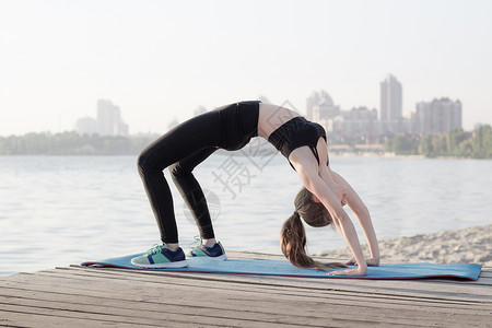 运动灵活的女性在弧桥瑜伽锻炼场伸展背景图片
