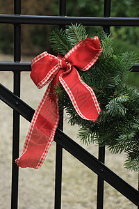 圣诞园地在围栏上庆典红色金子假期栅栏绿色房子松树背景图片