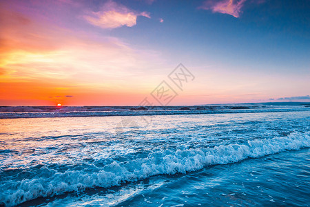 巴厘岛日落反射冲浪海滩地平线海洋海岸海浪海景橙子蓝色背景图片