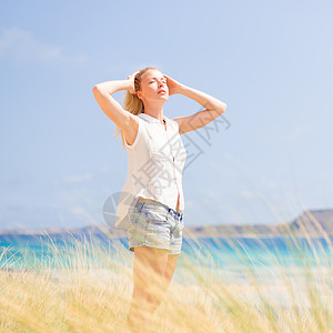 自由快乐的女子在节日中享受阳光冥想天空太阳喜悦生活女孩幸福沙丘海滩衬衫生活方式高清图片素材