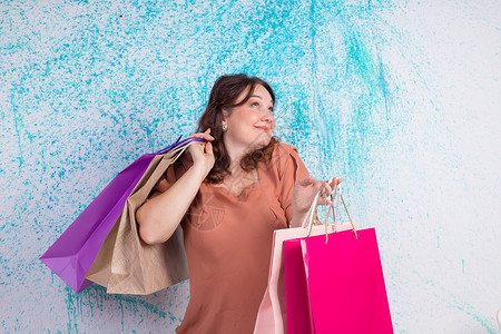 卖包包素材购物时笑得开心的女人拿着彩色纸袋 包包a背景