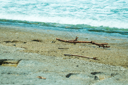 浮生如梦海水 海浪 沙子和石头 海洋泡沫 棍棒 困在海滩上背景