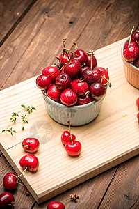 红色的碗陶瓷碗中的红熟樱桃蓝色桌布饮食果汁厨房制品木头宏观花园甜点背景