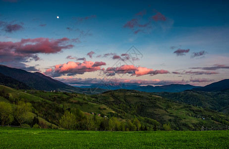 月亮谷黄昏和月亮时山丘的农村风景背景
