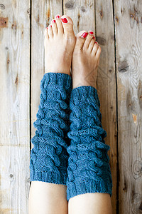 暖脚宝女人的腿在编织的长腿人身体女士蓝色女孩皮肤取暖器针织木头腿套羊毛背景