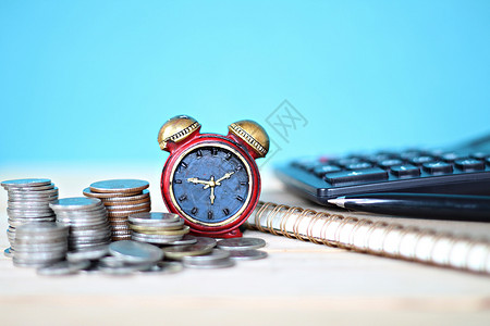 时钟和钱素材桌面桌上的微型时钟和硬币堆叠工作现金古董基金投资成功时间商业财富市场背景