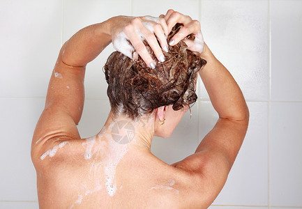 泡沫头女人在淋浴时洗头发的近镜头女士乐趣浴室成人卫生女性治疗肥皂身体皮肤背景