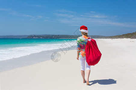 朴实无华在澳洲的圣诞节     妇女与节日一起在海滩上散步背景