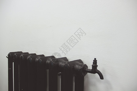 白色墙上的黑色钢制暖气散热器背景图片