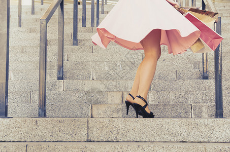 穿裙子的女孩带着纸包在楼梯上旋转高清图片