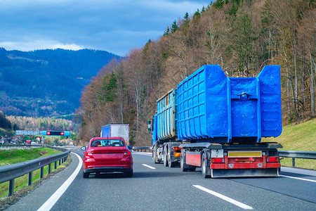 红色汽车在高速公路上飞越蓝色卡车高清图片