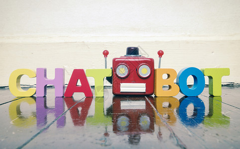 机器人对话在木地板上用红色机器人头的 CHATBOT字背景