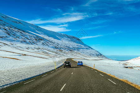 冬天有一条长长的直道公路和汽车地平线旅行场地农村车道孤独天空太阳场景蓝色背景图片