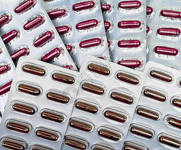 充气袋中的红色胶囊药 维生素和补充剂概念 医药包装工业 药房背景 (单位 美元)背景图片