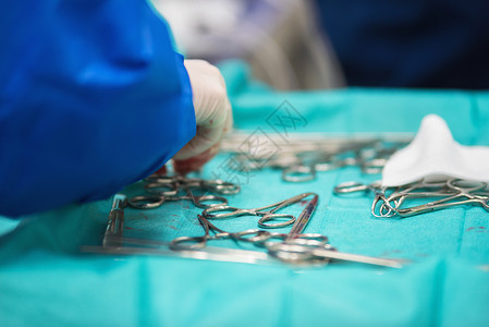 外科手从外科器械托盘上捡起工具治疗工作钳子医院医生药品团队诊所仪器卫生生活高清图片素材
