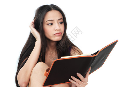 年轻女人向下看黑皮书聪明的高清图片素材