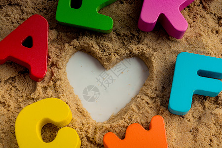 沙子上写着心形和彩色字母孩子知识公司课堂联盟字幕拼写训练文章教育学按字母顺序高清图片素材