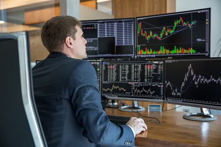 股票交易商在跟踪办公室的电脑屏幕上看金融的高清图片素材