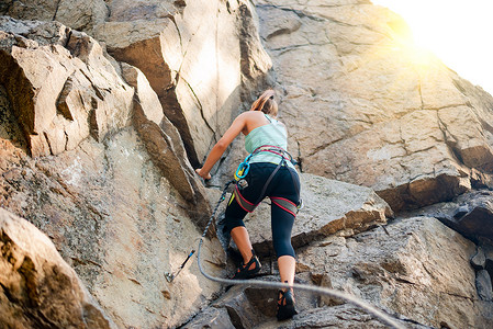 美丽的女人爬上山中的岩石 冒险和极限运动概念绳索天空肾上腺素风险女性挑战首脑悬崖旅行女孩爱好高清图片素材