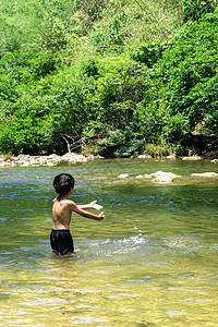 在河里玩水的亚裔男孩高清图片