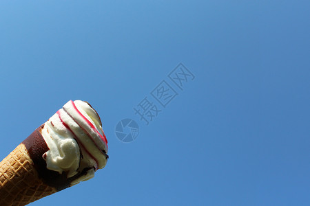 蓝天前的冰淇淋甜筒假期奶油天气香草蓝色酷暑节日短号天空甜点背景图片