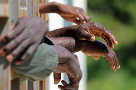 移徙的非洲黑人手握近身 紧贴人文两层海灵药监狱难民开发沉船联盟援助情况囚犯庇护背景图片