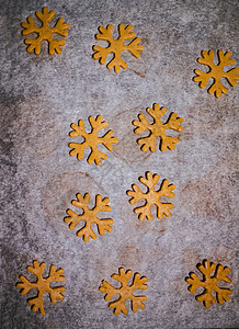 新年雪花饼干姜饼饼干切成雪花的形式 由生面团在深色背景的羊皮纸烘焙纸上制成 从上面看 节省空间滚动卡片柜台男生团体星星孩子明信片用具八角背景