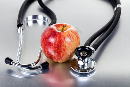 关于不锈钢的新鲜红苹果和听诊器背景图片