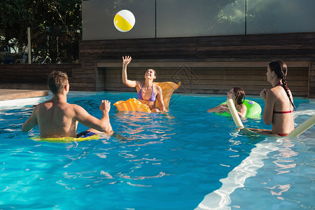 成人游泳人们在游泳池里玩球的人蓝色微笑乐趣男人女士女性假期闲暇朋友成人背景
