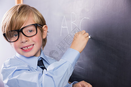 学生在大型黑板上写作早教男性学习金发女郎男生小学生金发微笑木板粉笔背景图片