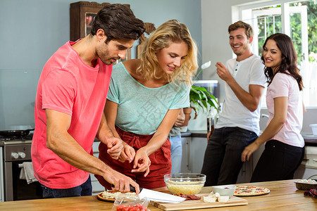 家庭用菜刀准备比萨饼的情侣背景