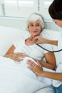 女医生用听诊器给老年妇女施教背景